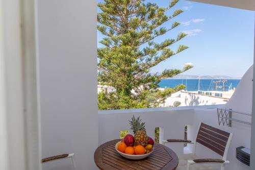 a bowl of fruit on a table with a view of the ocean at Naxos Illusion Nikos Verikokos in Naxos Chora
