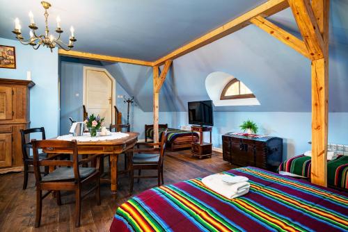 sypialnia ze stołem i pokój z 2 łóżkami w obiekcie Dwór Osmolice w mieście Białki Dolne