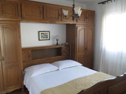 een slaapkamer met een groot bed en houten kasten bij Apartments Ena - near marina Kornati in Biograd na Moru