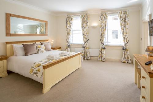 1 dormitorio con 1 cama, escritorio y ventanas en Hunter House Holiday Apartment - York, en York