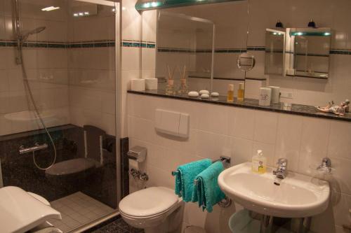 ein Bad mit einer Dusche, einem WC und einem Waschbecken in der Unterkunft 107-1 Helgoland in Wilhelmshaven