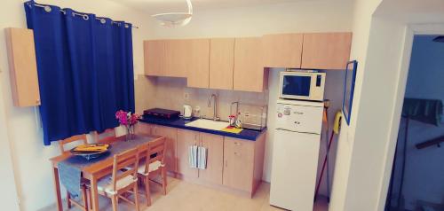 a kitchen with a refrigerator and a table in it at Zimmer-Eilat in Eilat