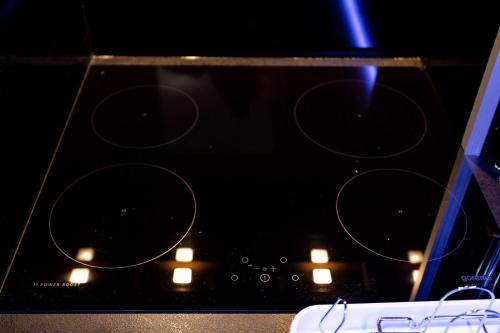 a black stove top with some lights on it at Apartmani Pezerović in Soko Banja
