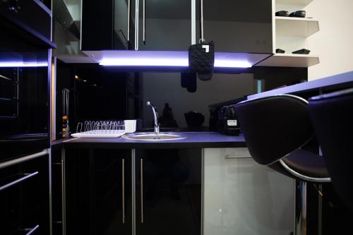 a kitchen with a sink and a blue light at Apartmani Pezerović in Soko Banja