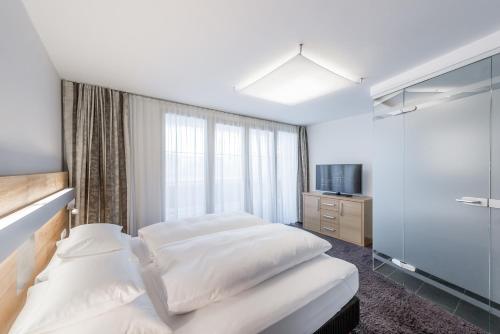 a hotel room with two beds and a television at Sport- und Genusshotel Silvretta in Ischgl