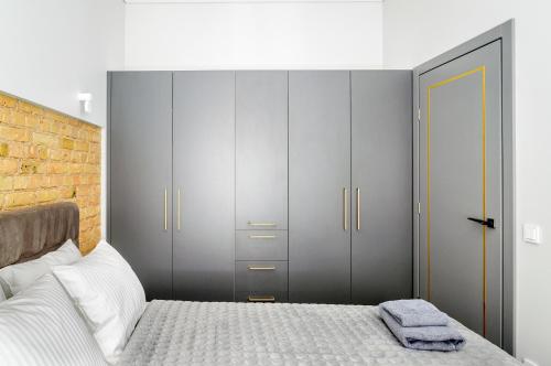 a bedroom with a bed and some gray cabinets at Malunu Apartments 1 in Vilnius