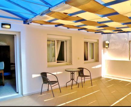 a room with a table and chairs and a blue ceiling at Studios Elina in Skala Potamias