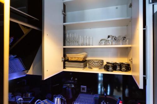 a kitchen cabinet with a sink and some glasses at Apartmani Pezerović in Soko Banja