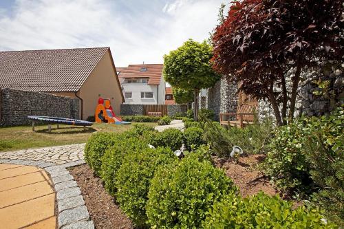 a garden with a playground in the back of a house at Hotel Hirsch in Leonberg