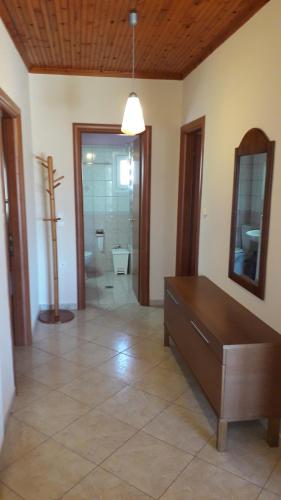 a living room with a table and a bathroom at HOUSE DILENA TSIMTSIRI in Limenaria