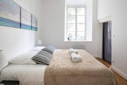 une chambre avec un grand lit avec des serviettes dessus dans l'établissement Cosmic by Cocoonr, à Rennes