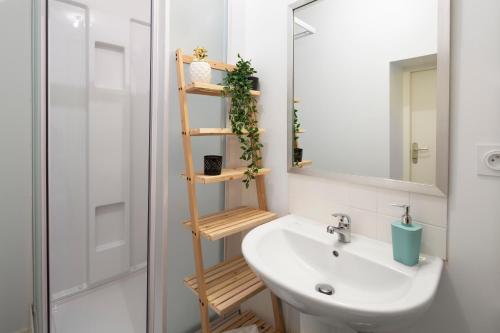 La salle de bains est pourvue d'un lavabo et d'une étagère avec des plantes. dans l'établissement Cosmic by Cocoonr, à Rennes