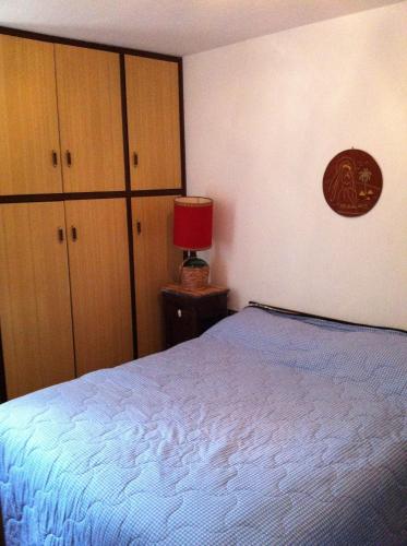 a bedroom with a bed and cabinets and a red lamp at Vip Foppolo in Foppolo