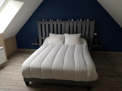 een slaapkamer met een groot wit bed en een blauwe muur bij Gîte à la ferme du Bailly - Baie de Somme in Saint-Quentin-Lamotte-Croix-au-Bailly