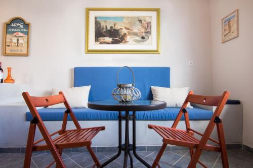 a blue couch with a table and two chairs at Finiki Studios in Karpathos Town