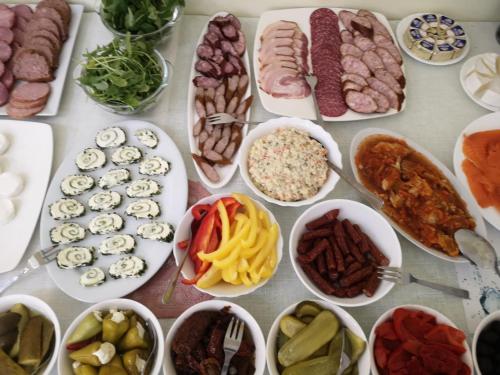 a table full of different types of food in bowls at Ośrodek Wypoczynkowy Nad Stawem vis a vis Parku Zdrojowego z Tężnią Solankową - B&B Holiday Resort By The Lake - Erholungsheim Am See - Prázdninový dům U Jezera in Kudowa-Zdrój