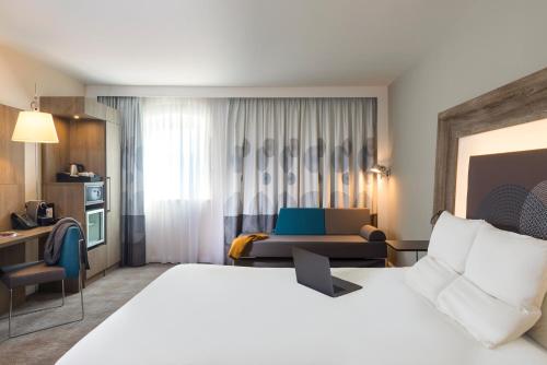 a hotel room with a bed and a desk at Novotel Coventry in Coventry