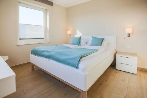 Schlafzimmer mit einem großen weißen Bett und einem Fenster in der Unterkunft Buedlfarm-Wohlfuehlhuette in Fehmarn