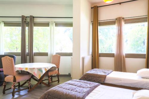 une chambre avec deux lits, une table et des chaises dans l'établissement ACCI Cannes Gallia, à Cannes