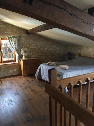 ein Schlafzimmer mit einem Bett und einem Holzboden in der Unterkunft LES GRANGES in Les Lèves-et-Thoumeyragues