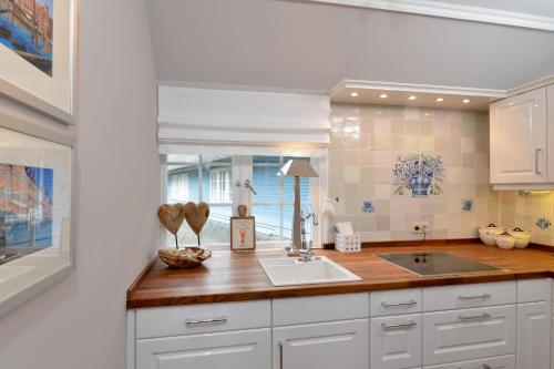 a kitchen with a sink and a counter at Alte Mühle direkt am Wattenmeer in Keitum