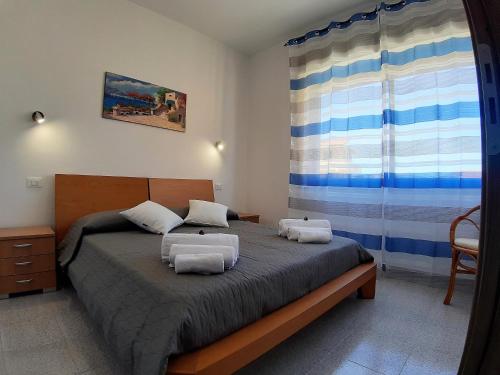 a bedroom with a bed with two chairs and a window at Living Piraino casa vacanze in Piraino