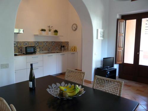 a kitchen with a table with a bowl of bananas on it at Residence Salina in Malfa