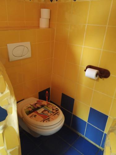 y baño con aseo y paredes de azulejos coloridos. en Penzion U strhaného klempíře, en Ropice