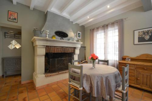a dining room with a table and a fireplace at les mazets de la reine Pédauque in Paradou