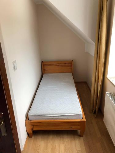 a small bedroom with a bed in the corner of a room at Pokoje gościnne Bursztynowa in Białogóra