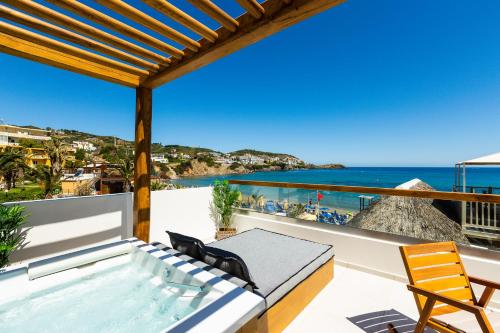 a view of the ocean from the balcony of a house at Nostos Beach Boutique Hotel in Balíon