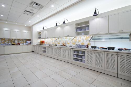 a large kitchen with white cabinets and white tile floors at Hyatt Place Ocean City Oceanfront in Ocean City
