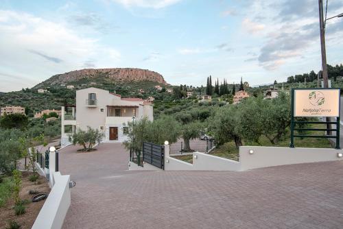 un edificio con un cartello e una montagna sullo sfondo di Nafplia Terra a Nauplia