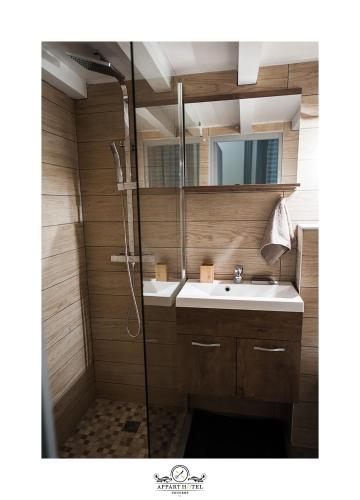 une salle de bain avec un lavabo et une douche dans l'établissement L'Impérial Appart Hotel Poitiers, à Poitiers