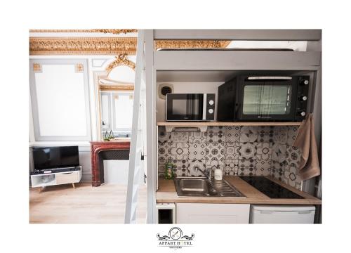 una cocina con fregadero y estufa en L'Impérial Appart Hotel Poitiers, en Poitiers