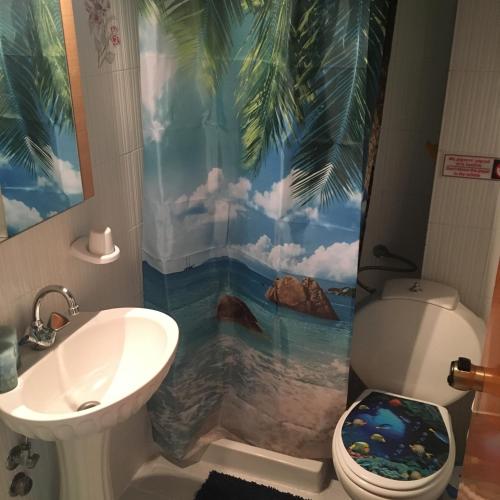 a bathroom with a shower with a palm tree mural at Dionisos Blue in Paralia Dionysiou