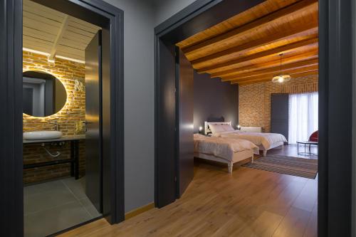 a bedroom with a bed and a mirror at Barba Boutique Hotel in Korçë