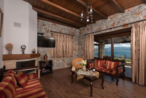 a living room with a couch and a fireplace at Sunset Traditional House in Ravdhoúkha