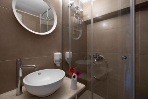 a bathroom with a white sink and a shower at Nelly's Apartments in Tolo