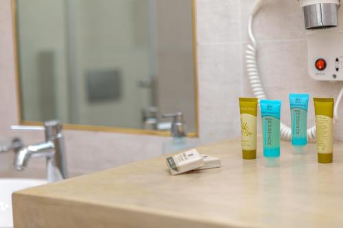 a counter with four toothbrushes and a sink in a bathroom at Naxos Illusion Nikos Verikokos in Naxos Chora
