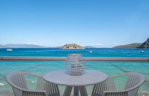a table with two chairs and a vase on it at Nelly's Apartments in Tolo