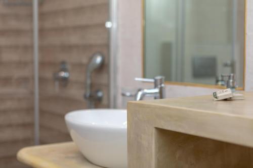 a bathroom with a white sink and a shower at Naxos Illusion Nikos Verikokos in Naxos Chora