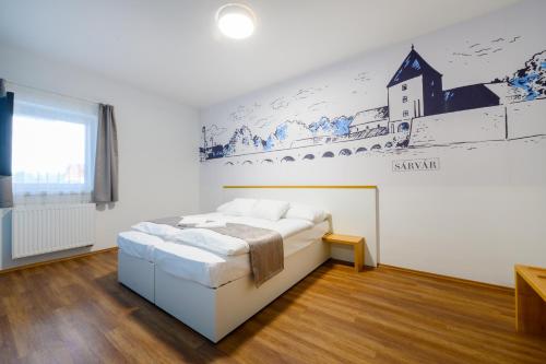 a bedroom with a bed and a wall with a mural at Berill Suites in Sárvár