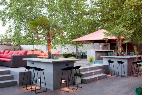 a patio with tables and stools and a couch at Hotel Puerta America in Madrid