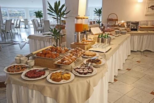 a buffet of pastries and other food on tables at Hotel Plaza in Porto Azzurro