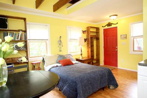 a bedroom with a bed and a table and a red door at Bon Paul & Sharky's Hostel in Asheville
