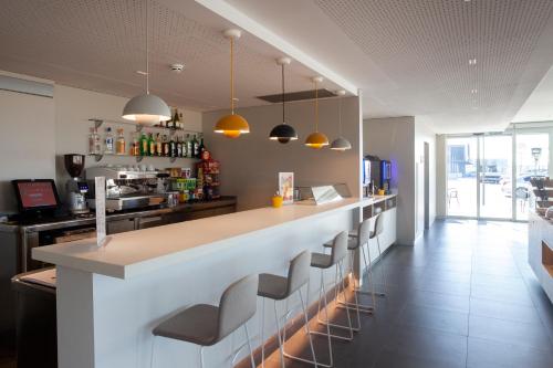 a kitchen with a bar with stools at Tramuntana in La Jonquera