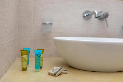 a bathroom with a sink and a tub and toothbrushes at Naxos Illusion Nikos Verikokos in Naxos Chora