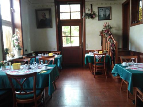 a dining room with tables with green tablecloths at Alte Kornbrennerei GBR in Poggenort