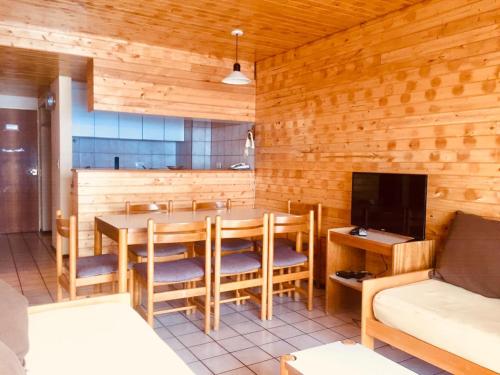 a dining room with a table and a tv at Apartur Las Leñas in Las Lenas